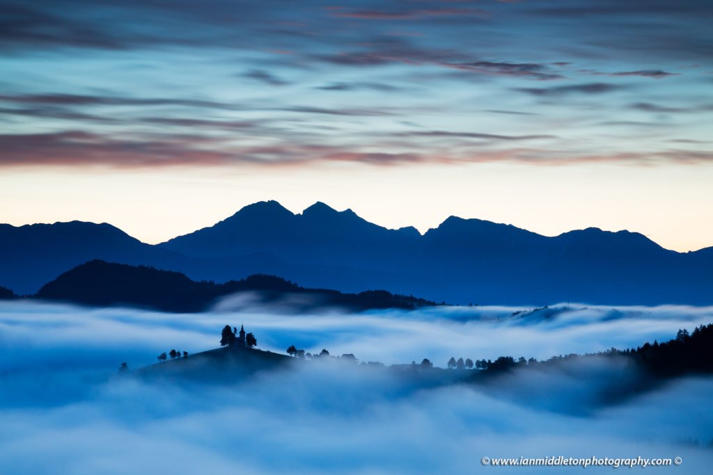 View at dawn from Rantovše hill across to Sveti Tomaz nad Praprotnim (church of Saint Thomas) and the Kamnik Alps, Slovenia.